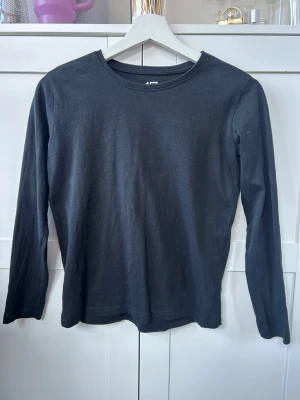 Svart långärmad topp från Lager 157  - En enkel och stilren svart långärmad topp från Lager 157 i mjuk bomull. Rund halsringning och normal passform. 