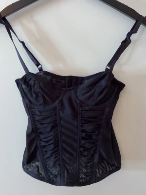 H&M korsett - Svart korsett ifrån H&M som man kan spänna i två olika storlekar i ryggen och justerbara band. 