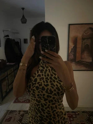 Leopardmönstrad halterneck - Säljer en leopardmönstrad halterneckklänning med öppen rygg och knytning bak. Klänningen har en figurnära passform och är gjord i ett stretchigt material som sitter snyggt på kroppen. Perfekt för dig som vill sticka ut med ett djurmönster.