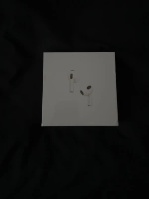 Äkta AirPods Pro (Oöppnade) - Säljer ett par vita Apple AirPods Pro med stilren design och laddningsetui. Hörlurarna är in-ear och har en kompakt, modern form. Perfekta för dig som vill ha grymt ljud och smidig anslutning till din iPhone eller andra Apple-enheter.