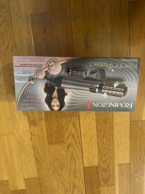 Remington Keratin Protect varmluftsborste - Remington Keratin Protect varmluftsborste i grå och roséguld. Inkluderar flera borsthuvuden för styling, volym och lockar. Borsten har keramisk beläggning och är designad för att skydda håret under styling. Perfekt för att skapa olika frisyrer hemma.