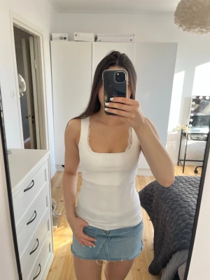 Vitt linne från Zara - Säljer en enkel och fräsch vit linnetopp med breda axelband. Toppen har en slim passform och dubbelsidig tyg för täckning vid bysten.🤗