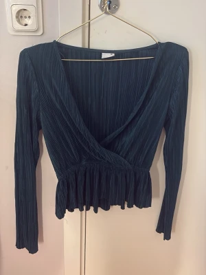 Fin grön tröja från Gina - En mörkgrön tröja från Gina tricot, den har ett litet randigt mönster och är väldigt tunn, tyget är mjukt, längst ner på tröjan går den utåt som en ”kjol” Storlek XS knappt använd då den var för stor där fram för mig, När jag väl hade den på mig så hade jag den bak och fram så att jag fick en öppen rygg istället. Funka jätte bra men tyckte inte att den var min stil.💕