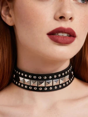 Svart choker med nitar och pyramidstuds - Cool svart choker i konstläder med två rader runda silverfärgade nitar och en rad stora fyrkantiga pyramidstuds i metall. Justerbar knäppning baktill. Perfekt accessoar för en edgy eller alternativ stil.Läderchocker. Halsband. 41,5 cm långt.