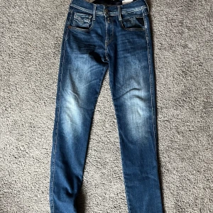 Replay Anbass jeans blåa str 28 . Waist 28 length 32 - Här är ett par snygga blå replay anbass jeans . 9/10 skick . Nypris 1800. Passar perfekt för den så kallade grishstilen