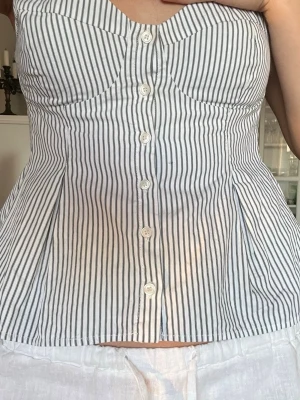 Randig korsettopp med knappar - Liten i storlek, har vanligtvis s/m i toppar. Liten defekt.