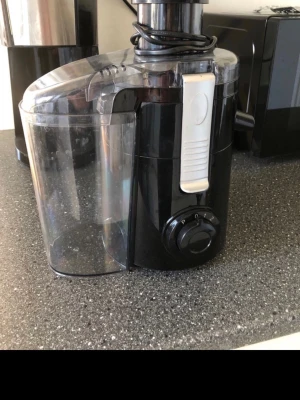 Svart juicepress från Nordic - Juicepress i svart plast från Nordic med transparent behållare och vridreglage på framsidan. Modern design med tydliga knappar och sladdförvaring. Perfekt för att snabbt göra färsk juice hemma. Man pressar ett glas i taget, därav ingen tillhörande kanna.