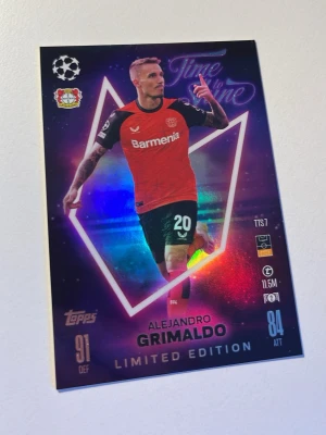Limited Edition fotbollskort Grimaldo - Säljer ett Limited Edition fotbollskort från Topps med Alejandro Grimaldo i Bayer Leverkusen. Kortet har holografisk effekt, lila och röda färger samt spelarens namn och statistik tryckt på framsidan. Perfekt för samlare av fotbollskort.