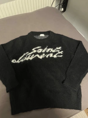 Saint laurent (YSL) tröja. - Köpte tyvärr fel storlek men har använts en gång. Inga skador och är i perfekt skick. Längden är 63 cm och axel breddet är 42 cm. Storlek M. Dens material är ull.