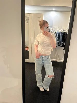 Zara baggy jeans - Säljer ett par ljusblå jeans med raka ben och en stor reva på ena knät. Perfekta för en avslappnad och trendig look. Inga defekter, dock avklippta vid fötterna se bild 5. Förstora i midjan passar mer som en M. Köpta från Vinted