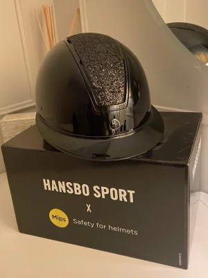 Hansbo ridhjälm  - Säljer nu min Hansbo ridhjälm på grund av att jag har slutat i sporten. Använd 3 gånger.  Aldrig tappad. Väldigt bra skick. Skriv gärna vid intresse. Storlek medium 55-57cm. Pris kan diskuteras 