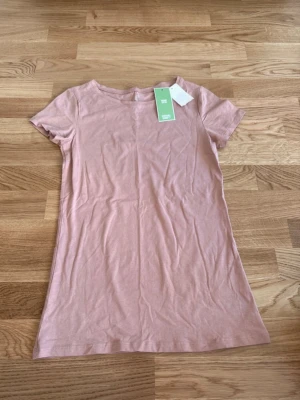 Ny T-shirt Kappahl stl XS - Ljusrosa t-shirt från KappAhl i ekologisk bomull. Helt ny, prislappen kvar. Nypris 99 kr.