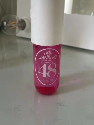 Sol de Janeiro Cheirosa 48 Parfymmist - En rosa parfymmist från Sol de Janeiro med doften Cheirosa 48. Flaskan är genomskinlig med vit text och har ett vitt spraylock. Perfekt för dig som gillar fräscha och söta dofter i en snygg och trendig förpackning.