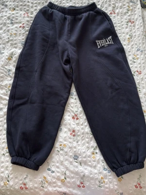  mjukisbyxor från Everlast zara collab - Säljer ett par blåa balloon mjukisbyxor från Everlast med broderad logga på vänster lår. Byxorna har resår i midjan och vid bensluten för en skön passform. Tillverkade i mjukt och bekvämt material, perfekta för chill eller träning.