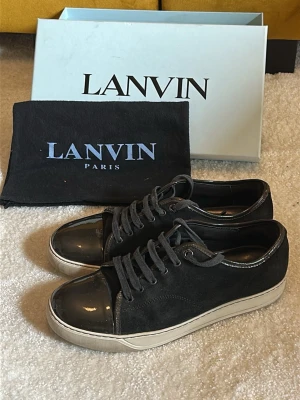 Lanvin Captoe mörkblå/svart - Hej! Säljer nu dessa väldigt populära och eftertraktade lanvin skorna! Perfekta till sommaren! Storlek UK 9 vilket motsvarar 43/44 i EU storlek!  Skick 9/10 (använda men ej slitna) Allt OG tillkommer vid köp (Box, Dustbag)  Ny pris= 5000 kr Säljs för= 2399 kr men går att förhandlas. Enda defekten är undersulan som har minemal heeldrag och därav priset. Glansen är dock näst intill perfekt! Tveka inte vid frågor!