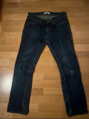 Mörkblå raka jeans från Acne - Snygga mörkblå jeans från Acne med raka ben och klassisk femficksdesign. Jeansen har kontrastsömmar och en stilren look som passar till det mesta. Tillverkade i denim med en autentisk känsla.