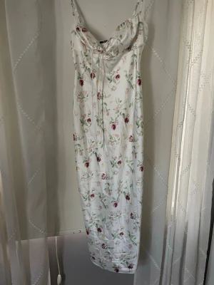 Satinklänning  - Blommig satinklänning ifrån Gina Tricot. Endast använd en gång. Mer än knälång. 