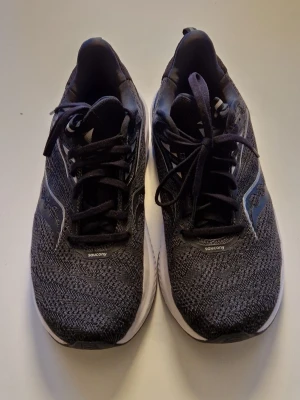 Saucony Echelon wide löparskor storl. 42.5 - Mörkgrå Saucony Echelon löparskor med stickad mesh-överdel och vita detaljer. Det är en herrmodell i storlek 42.5. Löparskorna har bra dämpning och är breda i lästen. Mycket sköna att löpa i men även som bekväm vardagssko. Sparsamt använda. 