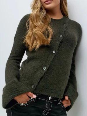 Mörkgrön kofta med sned knäppning - Mörkgrön kofta i mjukt stickat material från Gina Tricot Young med unik sned knäppning framtill och stora uppvikta ärmslut. Rund halsringning och flera knappar längs framsidan ger en cool och modern look 🫒 