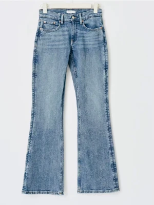 Blå bootcut jeans från Gina tricot - Säljer ett par ljusblå bootcut jeans från Gina med klassisk femficksdesign och snygga broderade detaljer på bakfickorna. Jeansen har låg midja och utsvängda ben, perfekta för en retroinspirerad look. Tillverkade i slitstark denim.