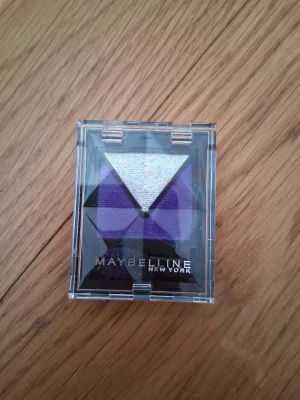 Maybelline ögonskuggspalett lila - Snygg ögonskuggspalett från Maybelline med fyra nyanser i lila och silver. Paletten har geometriska former och transparent plastlock. Perfekt för att skapa kreativa och färgstarka ögonmakeup-looks. Endast testad en gång