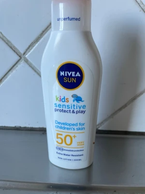 Nivea Sun Kids Sensitive SPF 50+ - Nivea Sun Kids Sensitive Protect & Play solkräm med SPF 50+ är speciellt utvecklad för barns känsliga hud. Oparfymerad och extra vattenresistent formula i en vit plastflaska med blå och gula detaljer. Innehåller 200 ml solskyddslotion.   Helt ny oöppnad säljes pga dubbelköp