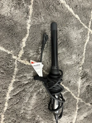 Svart locktång från Balmain - Snygg svart locktång från Balmain med sladd och värmeskyddande topp. Perfekt för att skapa mjuka lockar eller vågor. Ergonomiskt handtag och enkel att använda. Passar alla hårtyper och har en stilren design i svart plast och metall. De är original märket.
