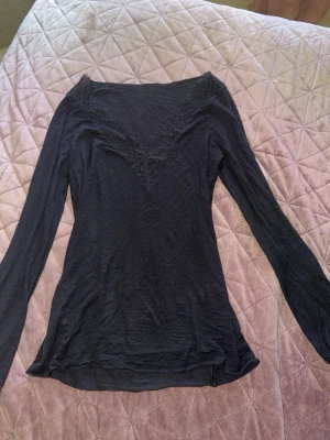 Intimissimi tröja  - Svart långärmad Intimissimi topp med snygg v-ringning dekorerad med spetsdetaljer. Tunn och mjuk, perfekt att matcha med jeans eller kjol. Materialet känns som bomull eller polyester och passformen är slim. Lite sliten längst ner vid ena armen (vid handleden) å ett pyttelitet hål långt ner ! Dem 2 defekterna visas på bild 3 å 4!