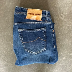 Jacob Cohen Jeans - Nyskick - (SÄLJER FÖR RIKTIGT BRA PRIS)  Tja. Säljer nu dessa Jacob Cohën jeans i riktigt fint skick, utan tecken på användning, använda fåtal gånger. Högsta kvalité på jeans. Nypris runt 5000 kr. Modellen är Bard och sitter slim (kolla bild 2). W31 men passar mer W32. Givetvis autentiska. Tveka inte på att ställa frågor! 🔥