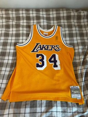 LA Lakers Jersey 1996-97 ”O’NEAL 34” - LA Lakers hemmalinne 1996-97 - XL - NY  Oanvänt LA Lakers hemmalinne med ”O’NEAL” #34 på ryggen. Storlek: XL Pris i butik: 1 200 - 1 500 kr Helt ny, inte ett dugg sliten . Skickas snabbt!  ENGLISH:  Unused LA Lakers home jersey with ”O’NEAL” #34 on the back. Size: XL Price in store: 110 - 130€ Brand new, not a bit worn. Shipped quickly!