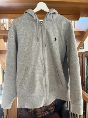 Grå ziptröja från Polo Ralph Lauren - Hej, jag säljer nu min as snygga och sköna Ralph lauren hoodie. Den säljs då den inte används längre. Den passar till allt och är perfekt under alla årstider. Storlek M. Det finns inga skador eller fläckar. Om det finns frågor eller funderingar är det bara att höra av sig🤝