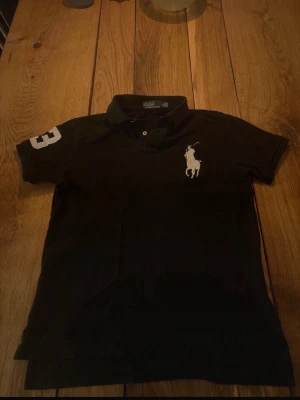 Polo Raulph Lauren Piké - Svart cheif keif pike från Polo Ralph. Den är äkta och är väldigt stiligt inför sommaren som kommer snart.