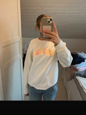 HOV1 merch - En vit hoodie från hov1 där det står ”vindar på mars” i gult, oranget och rött. Den har en liten fläck på framsidan och är i storlek s. 