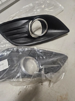 Svarta plastgaller till bil - Säljer två svarta plastgaller till bil, troligen för dimljus eller luftintag fram. Ena har en silverfärgad ring runt öppningen. Passar till montering på bilens front. Levereras i plastpåse. Ford focus