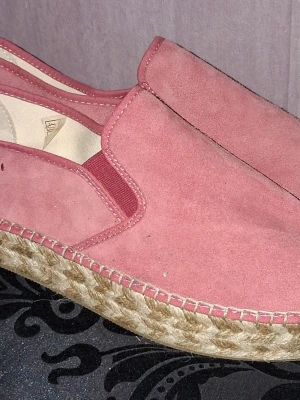 Odd Molly Espandrillos  - Säljer ett par rosa Espandrillos från Odd Molly i mocka med flätad sula i jute och gummiyttersula. Skorna har elastiska partier på sidorna och färgglad innersula med mönster och logga. 