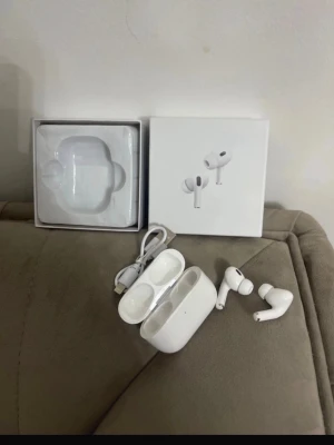 Apple AirPods Pro med laddningsetui - Säljer ett par vita Apple AirPods Pro med trådlöst laddningsetui och lightning-kabel. Hörlurarna har in-ear-design och silikonproppar för bra passform. Snygg och stilren look, perfekt för musik och samtal. Originalförpackning och tillbehör medföljer.