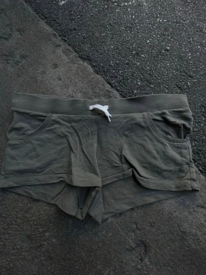 Gröna shorts med snörning från Divided - Snygga gröna shorts från Divided by H&M med vit snörning i midjan och två fickor framtill. Tillverkade i mjuk bomull, perfekta för varma dagar. Avslappnad passform och midwaist-modell.