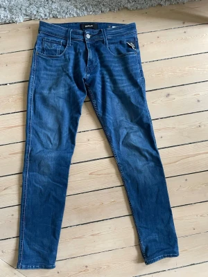 Blå anbass jeans från Replay 30/32 - Säljer ett par blå slim fit jeans från Replay med klassisk femficksmodell och snygga detaljer Perfekta till en avslappnad stil. 