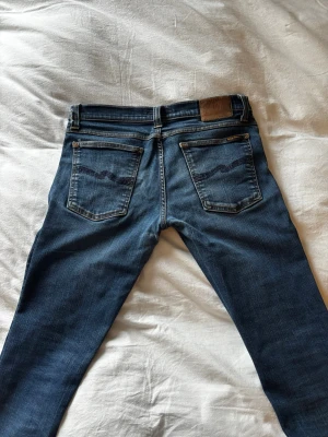 Vintage Nudie grim tim jeans - Säljer ett par vintage Nudie jeans. Jeansen är i modellen grim Tim och storlek 30/32. De är mycket sköna och snygga. Hör av er vid eventuella frågor eller funderingar. Skickar gärna fler bilder om de önskas!