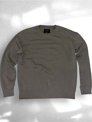 Jack & jones tröja - En stilren brun tröja från jack & jones i mjuk bomull. Tröjan har rund halsringning, långa ärmar och ribbade muddar vid ärmslut och nederkant. Perfekt för en avslappnad och clean look. Storlek S. 