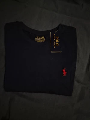 Ralph Lauren - Säljer en t-shirt från Ralph lauren | I färgen marinblå med röd logga och storlek S | Helt ny och fräsch | Hör av er för mer information/bilder! 