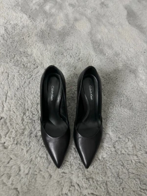 Svarta klackar från Calvin Klein - skickar idag  - Jättefina svarta Calvin Klein klackskor som användes 1 gång på ett födelsedagskalas. De är normala i storleken. Det är damm som syns på bilderna på klackarna! Har ej lådan kvar då jag trodde att de skulle bli använda mycket mycket fler gånger. Jag har tyvärr för många och dessa kommer tyvärr ej till användning😩 Jättefina och i jättefint skick, som nya! 🥰  #klackskor #stilettoklackar #klackskorsvarta #svartaklackskor #calvinklein #ck #calvinkleinklacksor #stilettoklackar #dam