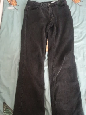 Svarta jeans från Vero Moda - Säljer ett par svarta jeans från Vero Moda med klassisk femficksmodell och raka ben. Jeansen är tillverkade i denim och har en enkel design som passar till många olika stilar.