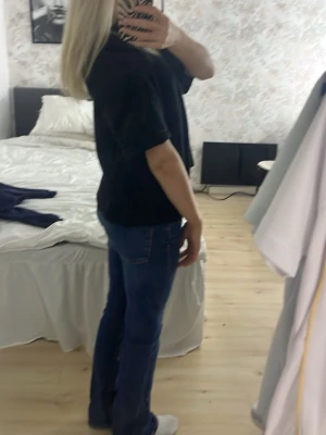 Blå bootcut jeans med klassisk passform - Säljer ett par blå bootcut jeans med klassisk passform och normal midja. Jeansen har fem fickor och är tillverkade i denim med lätt stretch för bekväm känsla. Perfekta för dig som gillar en tidlös och avslappnad stil.