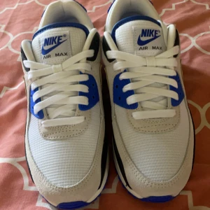 Nike Air Max i vit och blå - Säljer ett par fräscha Nike Air Max sneakers i vit och blå. De har en klassisk design med snörning och en bekväm passform. Perfekta för både vardag och träning. Skorna har synliga täcken på användning lite smutsig med såklart man jag rena till dom extra bra inget defekt och redo för nya äventyr!ny pris 1700)