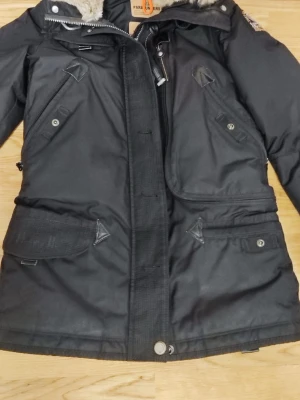 Svart parkas från Parajumpers XS - Snygg svart parkas från Parajumpers i modellen Masterpiece Series. Jackan har flera fickor med knappar och dragkedjor, hög krage med fuskpäls och detaljerade sömmar. Perfekt för kalla dagar och riktigt stilren look. Nypris: 10 000. Mitt pris: 4 500 men kan diskuteras. Kontakta mig vid intresse. 