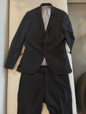 Svart kostym från Tiger of Sweden - Svart kostym från Tiger of Sweden. Storlek 52. Modell Evert. Mycket bra skick. Nypris ca 6000 kr. Går även att köpa byxor och kavaj separat.