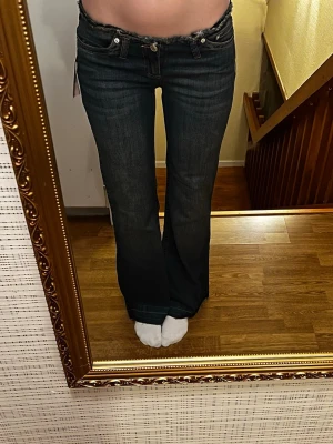 Nya lågmidjade Nelly jeans - Helt nya trendiga mörkblå lowwaist utsvängda jeans från Nelly i storlek 34 short. Modellen heter No Waist Bootcut Jeans