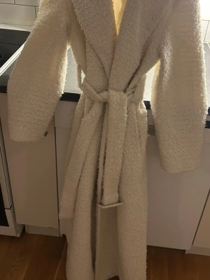 Kappa - Vit lång kappa använd fåtal gånger passar inte,den är uppsprätt (se bild 3) för att tagit ut axelvaddar annars jätte fint skick 