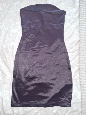 Bandeau klänning hm divided  - Bandeau kort klänning i glansigt material. Klänningen har en figurnära passform och är perfekt för dig som vill ha en stilren och enkel look. Brun färg, använt 1 gång💥